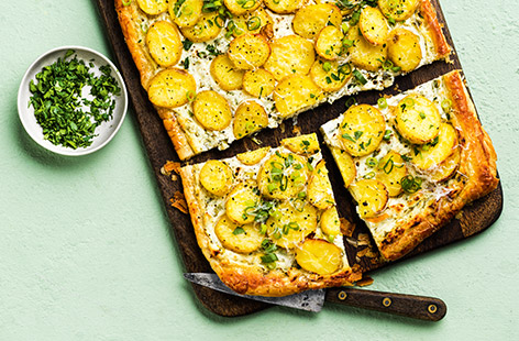 Baby potatoes, spring onions and a variety of creamy and tangy cheeses create this super spring tart, perfect for entertaining or a simply delicious dinner with leftovers for lunch.