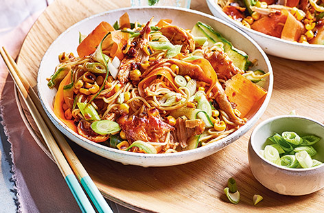 Chicken noodles meets salad in this flavour-packed and budget-friendly family dinner. Sweet and spicy gochujang paste adds oomph to juicy chicken drumsticks, which are baked and shredded into cooked egg noodles with charred corn, carrot, cucumber and spring onion. 