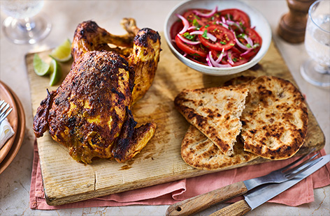 Switch up your roast with this tangy lime pickle marinated chicken. Serve with a fresh Goan-inspired tomato salad and sweet coconut Peshwari naan, warm from the oven. 