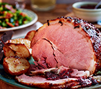 Baked ham with cranberry glaze, roasted pears and bacon greens | Tesco Real Food